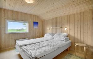 1 dormitorio con 1 cama en una habitación con paredes de madera en Awesome Home In Stege With Sauna en Stege