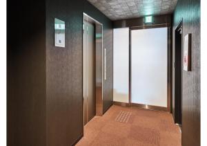 un pasillo con una puerta abierta en un edificio en HOTEL LEGASTA KYOTO SHIRAKAWA SANJO en Kioto