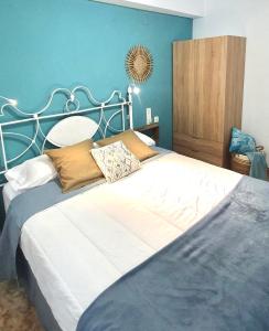 a bedroom with a large bed with a blue wall at Monela Front beach in Playa de Gandia