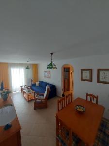uma sala de estar com um sofá azul e uma mesa em Aguamarina, cerca de todo em La Antilla