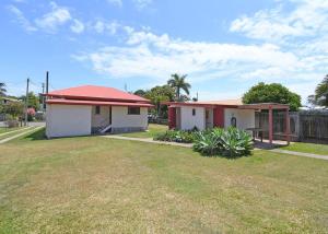 two small houses in a yard next to a fence at Family Tides in Urangan