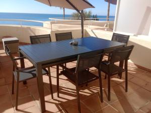 niebieski stół i krzesła na balkonie z widokiem na ocean w obiekcie El Mirador de Estepona w mieście Estepona