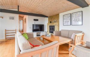 een woonkamer met een bank en een tafel bij Nice Home In Assens With House Sea View in Assens