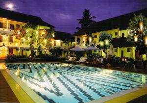 a swimming pool at night in a hotel at Karinthip Village in Chiang Mai