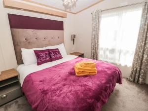 sypialnia z dużym łóżkiem i fioletowym kocem w obiekcie La Hacendia Lodge w mieście Morpeth
