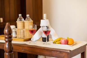 dos copas de vino tinto en una mesa con fruta en Nivas Boutique Home en Katmandú