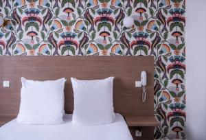 a bedroom with a bed with a headboard and a wallpaper at Sure Hotel By Best Western Lorient Centre in Lorient