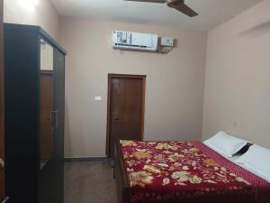 een slaapkamer met een bed en airconditioning aan de muur bij Green Hills Farm And Guest House in Masinagudi
