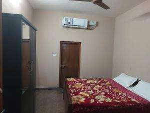 a bedroom with a bed and a air conditioner on the wall at Green Hills Farm And Guest House in Masinagudi