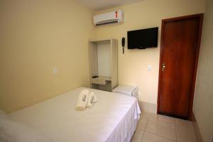 um quarto de hotel com uma cama com duas toalhas em Pousada Badejo em Japaratinga