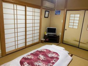 a room with a bed and a tv in it at 花緑里-Hanamidori-菅田ほたるの里 岐阜下呂関田園里山リゾート in Gujo