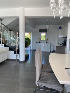 a kitchen and dining room with a white table and chairs at Amazing Villa with panoramic sea view in Paphos City