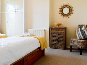 Ivy Cottage في Newchurch: غرفة نوم بسرير ومرآة وكرسي