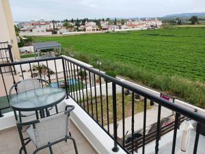 un balcone con tavolo, sedie e campo verde di Beautiful 2-Bed House in Mandria paphos a Mandria