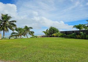 un parque con palmeras y césped en Ann's Beach House, en Rarotonga