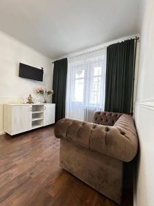 uma sala de estar com um sofá e uma televisão em Апартаменти в центрі біля Либідь-Плази em Khmelnytskyi