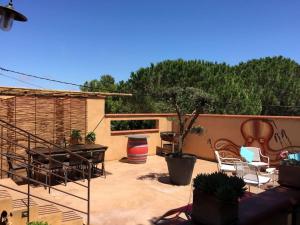 eine Terrasse mit Stühlen, einem Baum und einem Zaun in der Unterkunft Le Jardin des vignes in Canet-en-Roussillon
