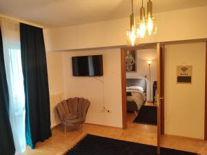 ブカレストにあるHistoric Center Residence 2のテレビと椅子のあるリビングルームと寝室