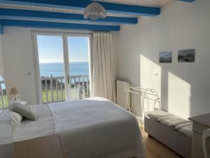 sypialnia z łóżkiem i dużym oknem w obiekcie Villa face mer aux magnifiques couchers de soleil 5 mn de Nausicaa w mieście Boulogne-sur-Mer