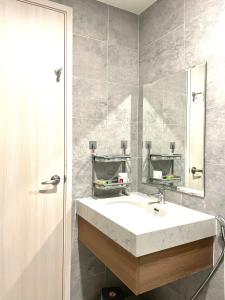 y baño con lavabo blanco y espejo. en Hoa's lovely 2-bedroom condo with pool, en Ấp Phú Thọ