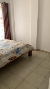 a bed sitting on a tiled floor in a room at Oasis comfort in Nairobi