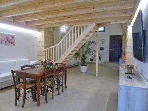 a dining room with a wooden table and a staircase at Glem Luxury in Copertino