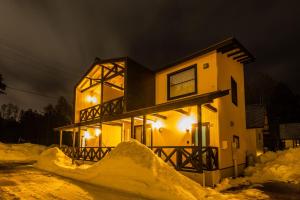 a house with snow piled up around it at night at WHITE HAKUBA in Iida