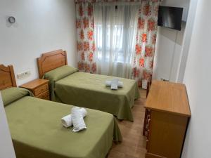 een hotelkamer met 2 bedden en handdoeken erop bij Camiño Portugues in Padrón