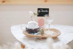 stół z dzbankiem do herbaty i kieliszkiem wina w obiekcie Najai Home Stay lamphun w mieście Lamphun
