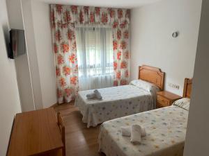 Un pequeño dormitorio con dos camas y una mesa. en Camiño Portugues, en Padrón 12 fotos más
