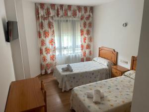 1 dormitorio pequeño con 2 camas y mesa en Camiño Portugues, en Padrón