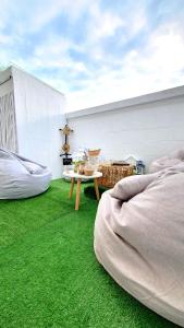 une chambre avec de l'herbe verte et une table sur un balcon dans l'établissement Najai Home Stay lamphun, à Lamphun