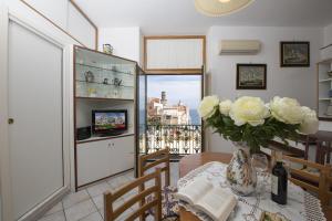 a dining room with a table with a vase of flowers at La casa di Carmela - Amalfi Coast in Atrani