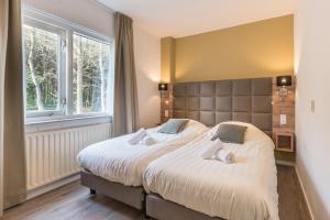 ein Schlafzimmer mit einem großen Bett und einem großen Fenster in der Unterkunft Appartementen Bos en Duin Texel in Den Hoorn