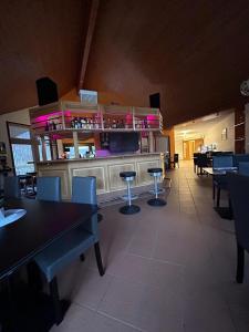 a restaurant with a bar with tables and chairs at Hôtel EDIROL in Vouvry