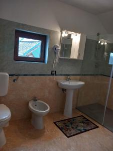 a bathroom with a toilet and a sink and a shower at Casa Rasaritul Soarelui Sarichioi in Sarichioi