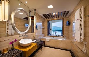 Good View Hotel Tangxia - 15 mins drive from Dongguan South Railway Station في دونغقوان: حمام مع حوض وحوض استحمام ومرآة