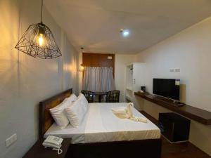 ein Hotelzimmer mit einem Bett mit Telefon darauf in der Unterkunft Dumaguete Seafront Hotel in Dumaguete