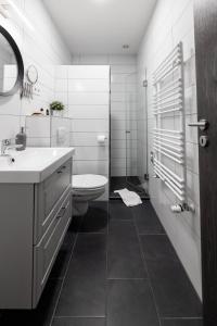 a white bathroom with a toilet and a sink at Roomstore Studio Apartments in Eger