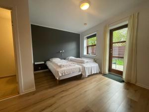 a bedroom with two beds and a large window at Bui Hotel Humble in Humble