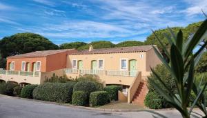 a large house with bushes and trees on a street at Chez K&D Studio Nature avec piscine St Raphaël in Saint-Raphaël