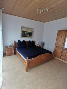 1 dormitorio con cama con sábanas azules y techo de madera en Haus zum Talblick, en Solnhofen