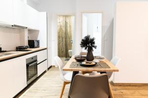eine Küche und ein Esszimmer mit einem Tisch und Stühlen in der Unterkunft Pebble Garden Blue Dahlia in Kos-Stadt
