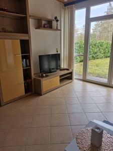 a living room with a tv and a large window at Haus zum Talblick in Solnhofen