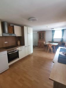 una cocina con armarios blancos y una mesa en una habitación en Haus zum Talblick, en Solnhofen