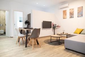 a living room with a couch and a table and chairs at Pebble Garden Blue Dahlia in Kos Town