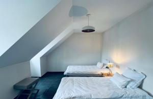 twee bedden in een kamer met een trap bij ZEN op Vakantie - Zen aan De Gavers in Onkerzele