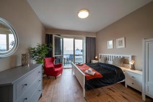 プラハにあるNew Town - Apple Apartmentsのベッドルーム1室(ベッド1台、デスク、赤い椅子付)
