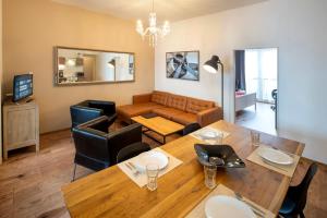 una sala de estar con una mesa y un sofá en New Town - Apple Apartments, en Praga