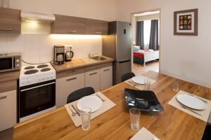プラハにあるNew Town - Apple Apartmentsのキッチン(ダイニングルームと木製テーブル付)